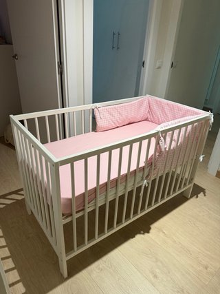 Cuna de madera blanca con protector rosa