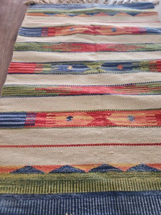 Alfombra tejida multicolor con flecos