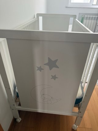 Cuna colecho blanca con osito y estrellas.