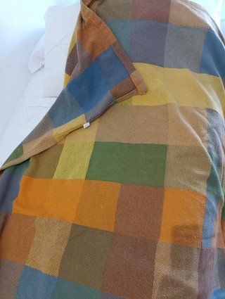 Colcha de tela azul ,amarilla y verde, de cuadros