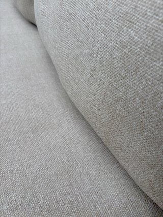 Sofá de terraza beige con cojines y mesa auxiliar