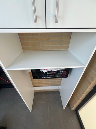 Armario blanco con puertas y estante.