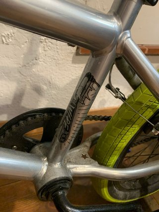 Bicicleta BMX plateada con ruedas verdes