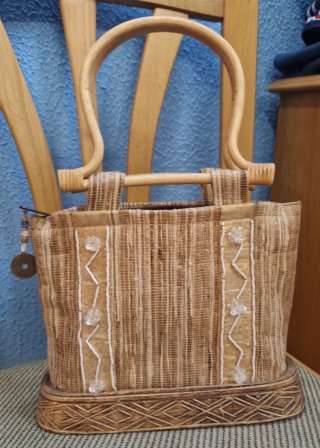Bolso de mano de rafia y detalles dorados