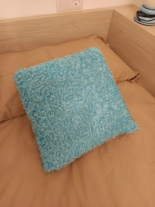 Cojín decorativo azul con olor a lavanda.