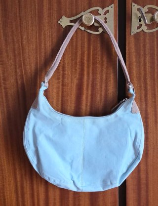 Bolso azul claro con detalles beige.