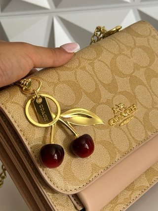 Bandolera coach con charm de cerezas