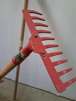 Rastrillo rojo con mango de madera