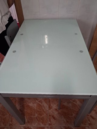Mesa de comedor o cocina de cristal y metal gris.