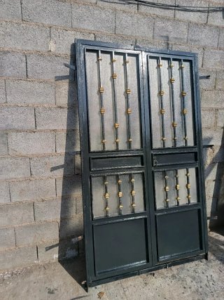Puerta de hierro con cristal y detalles dorados