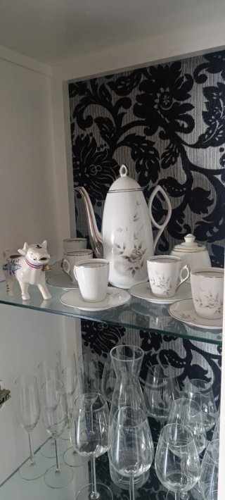 Mueble vajillero lacado con fondo tapizado.