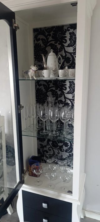 Mueble vajillero lacado con fondo tapizado.
