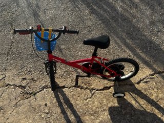 Bicicleta infantil roja con ruedines