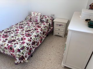 Dormitorio juvenil con colcha y cortina.