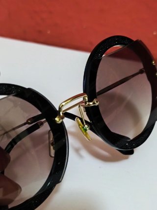 Gafas de sol Miu Miu negras y doradas