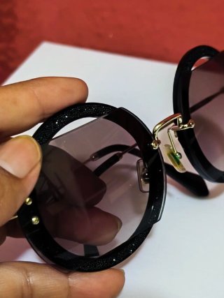 Gafas de sol Miu Miu negras y doradas