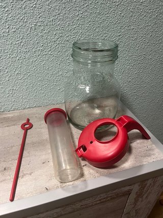 Jarra de vidrio con tapa roja y enfriador