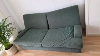 Sofá verde con manta multicolor