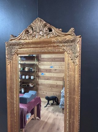 Espejo de pie dorado con marco decorado