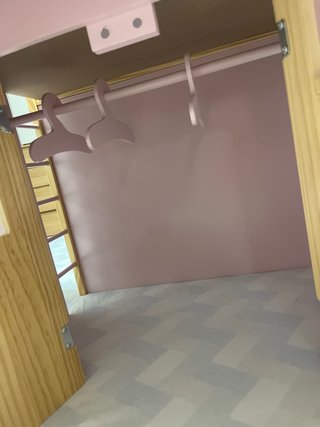 Casita de muñecas de madera rosa.