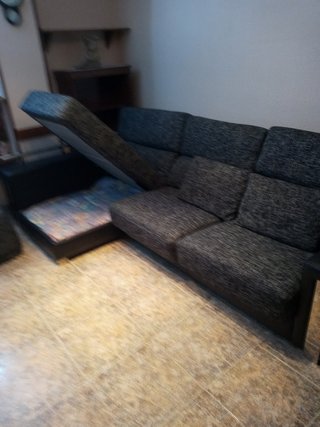 Sofá esquinero gris con detalles plateados