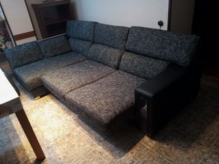 Sofá esquinero gris con detalles plateados