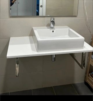 Lavabo de cerámica blanco con encimera y toalleros
