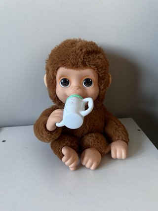 Mono de peluche bebé con biberón