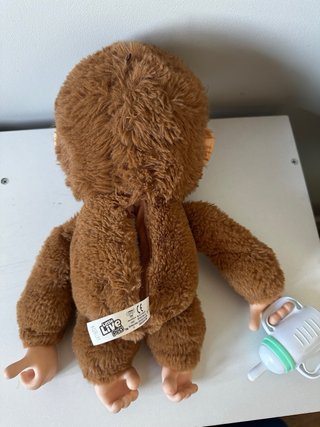 Mono de peluche bebé con biberón