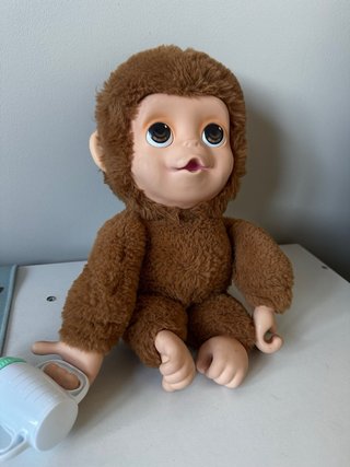 Mono de peluche bebé con biberón