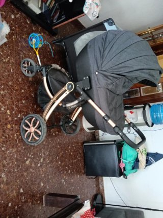 Carrito de bebé gris y dorado.