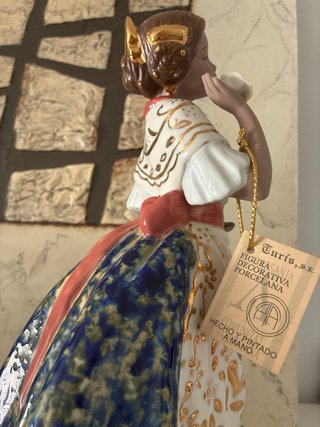 Figura de porcelana con flores y detalles dorados