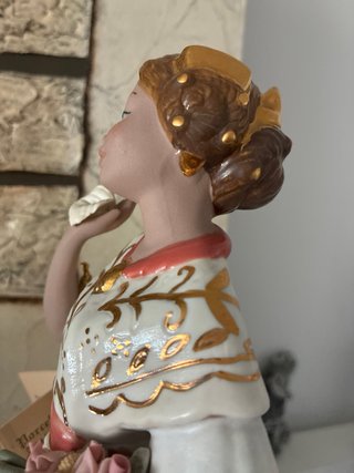 Figura de porcelana con flores y detalles dorados