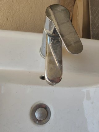 Lavabo de cerámica con grifo y latiguillos