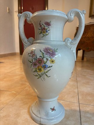 Paragüero antiguo de cerámica con flores.