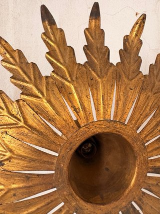 Lámpara de pared dorada estilo sol