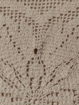 Colcha antigua de tela beige.
