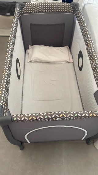 Cuna de viaje gris con cambiador