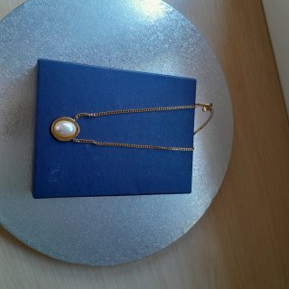 Collar de acero dorado con perla
