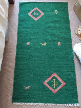 Alfombra verde con perros y rombos