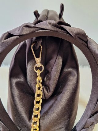 Bolso de mano marrón con cadena dorada
