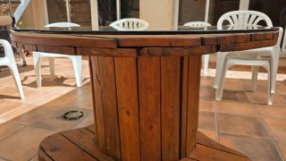 Mesa de jardín de madera. Bobina de cable.