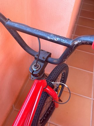 Bicicleta Roja Con signos de desgaste y freno roto