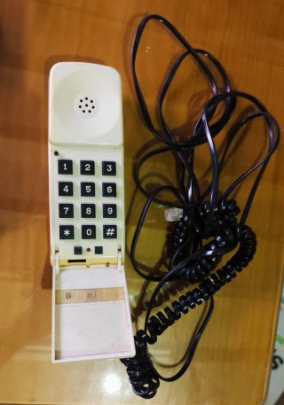 Teléfono antiguo beige con cable negro