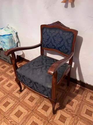 Sillón bajo antiguo de madera y tela.