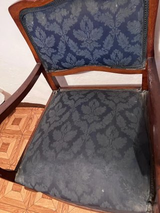 Sillón bajo antiguo de madera y tela.