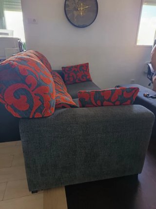 Sofá gris y rojo con cojines