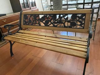 Banco de forja y madera con diseño floral