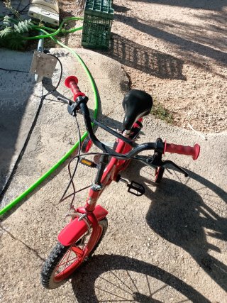 Bicicleta infantil roja con ruedines