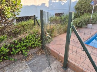 Valla metálica para piscina con puerta y postes.